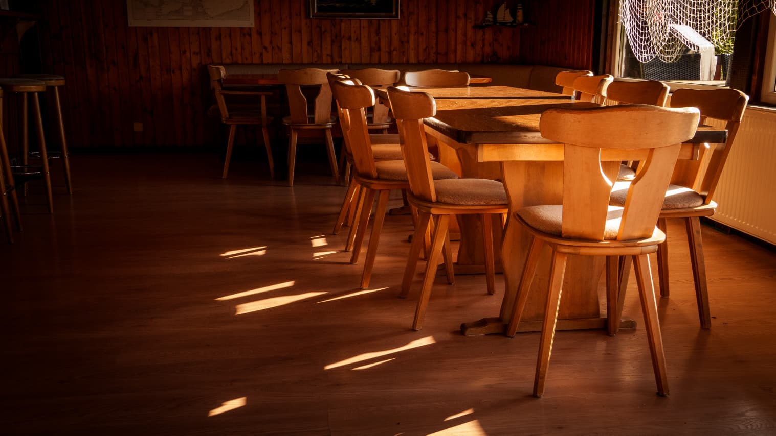 Aufenthaltsraum im Clubhaus mit Holzvertäfelung und Abendsonne
